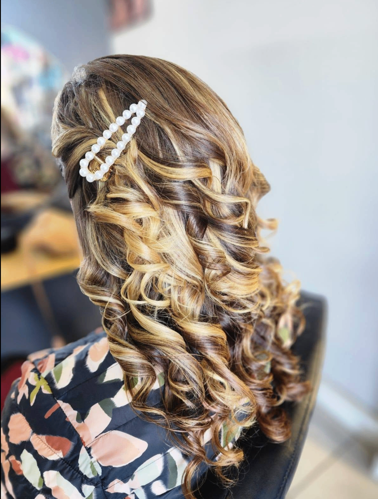 Elegant half-up curls with pearl clips after styling at Belle Vee